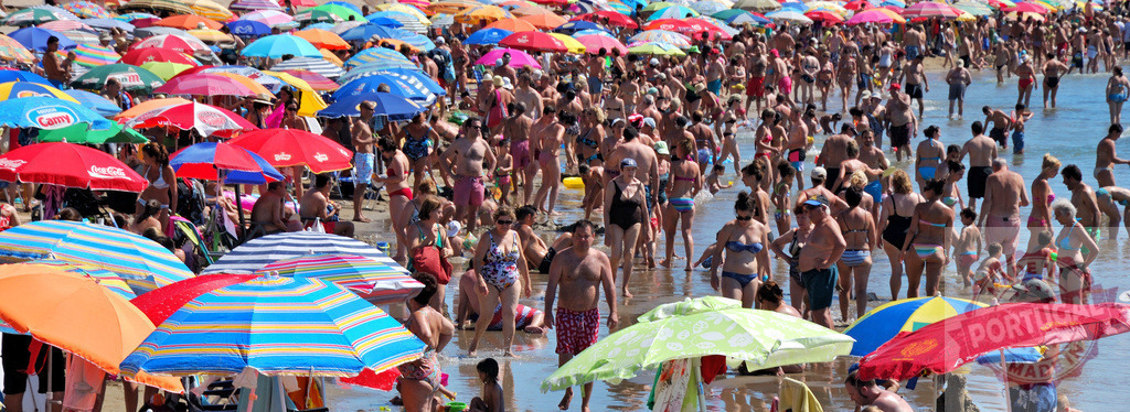 Crowded beach with many people and colorful umbrellas | People enjoying warm summer day under numerous colorful beach umbrellas on a crowded beach - Realized with Pictrs.com