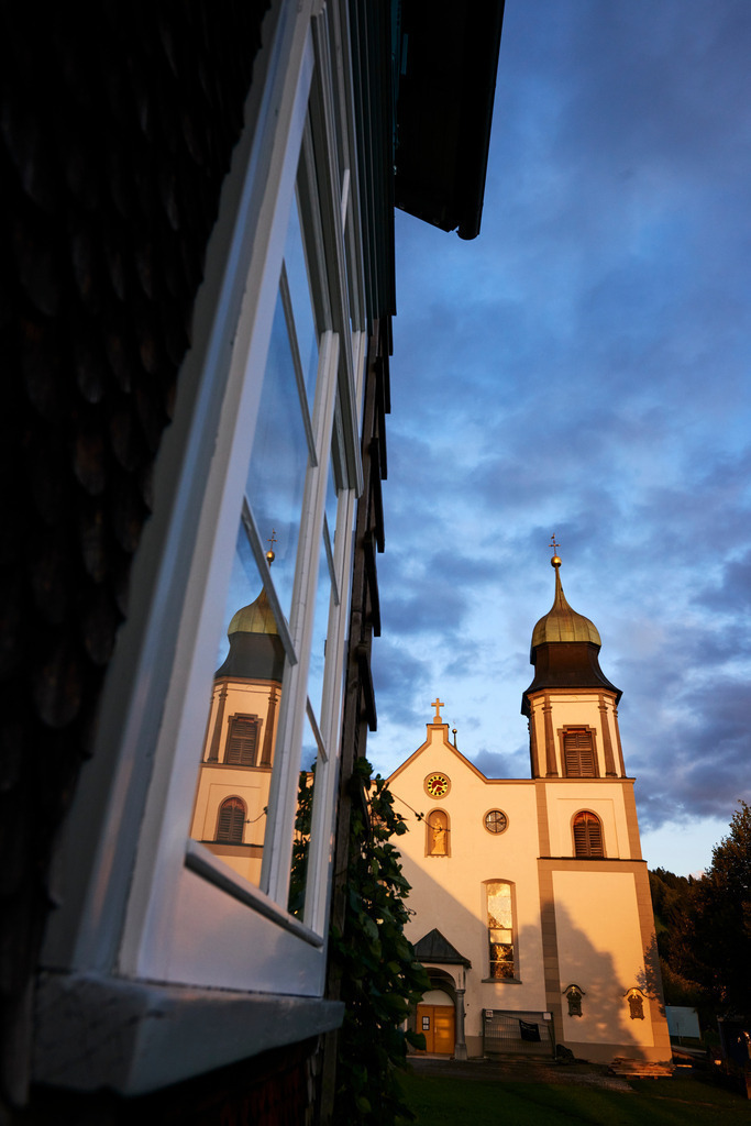 Spiegelung der Wallfahrtskirche Maria Heimsuchung | Bildstein, Austria - September 14, 2017: Spiegelung der Wallfahrtskirche Maria Heimsuchung im Fenster des Rathauses. - Realisiert mit Pictrs.com