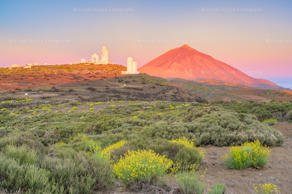 Teide-Observatorium | Das Teide-Observatorium, gelegen auf der Insel Teneriffa, ist ein herausragendes Zentrum für astronomische Beobachtungen. Es wurde 1964 eröffnet und befindet sich auf dem Berg Izaña in 2400 Meter Höhe, was es zu einem idealen Standort für die Erforschung des Himmels macht. Das Observatorium ist Teil des Instituto de Astrofísica de Canarias und spezialisiert sich auf die Sonnenbeobachtung, die im Verbund mit anderen Observatorien rund um die Uhr durchgeführt wird. Besucher können an geführten Touren teilnehmen, um mehr über die faszinierende Welt der Astrophysik zu erfahren und die Sonne durch spezielle Teleskope zu beobachten. Mit dem Teide im Hintergrund ist es dazu ein schönes Motiv, vor allem bei Sonnenaufgang, wenn der Teide in einem tiefen Rot erstrahlt. - Realisiert mit Pictrs.com