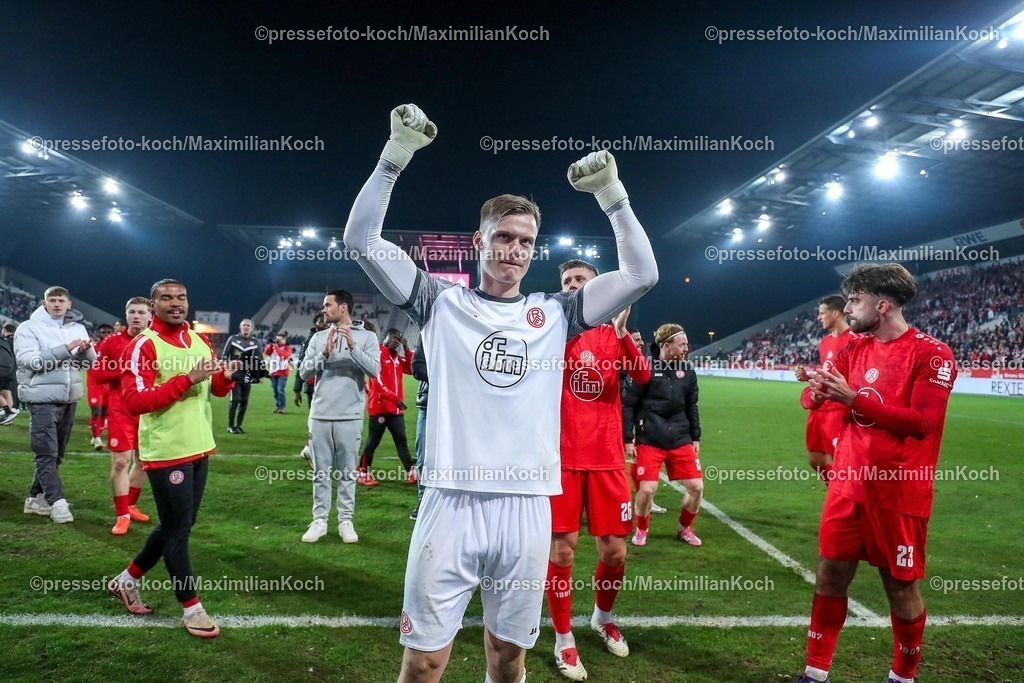 RWE09032501042 | 2025.03.09, Fußball, 3.Liga, Rot-Weiss Essen - SV Waldhof Mannheim, Stadion Hafenstraße, Saison 2024 2025: Abschlussjubel nach dem 1:0 Sieg für RWE.  Die Mannschaft steht jubelnd auf dem Spielfeld und feiert vor den Fans. Torwart Jakob Golz (RWE #1)DFB regulations prohibit any use of photographs as image sequences and or quasi-video.