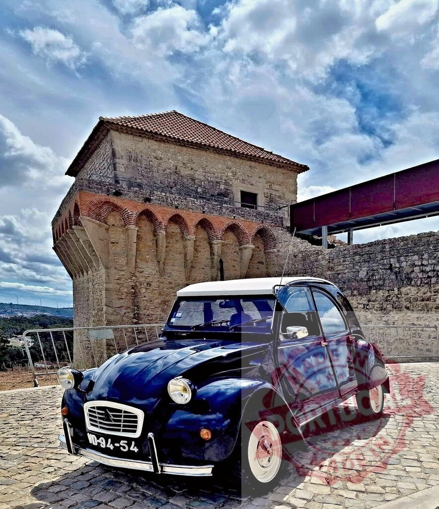 Classic Citroën 2CV parked near the Castle of Leiria in Portugal | Blue vintage car parked in front of the medieval castle of Leiria in Portugal, under a blue sky with clouds - Realisiert mit Pictrs.com