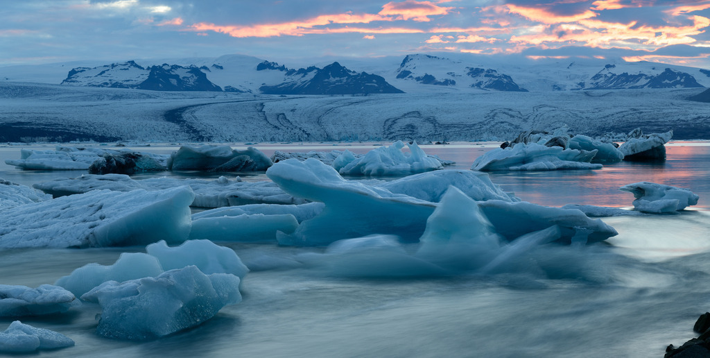 island-2019-312 | Jökulsárlón ist eine Gletscherlagune, die an den Nationalpark Vatnajökull im Südosten Islands angrenzt. Im Wasser schwimmen unzählige Eisberge des Vatnajökull-Gletschers. Die Lagune fließt durch einen kurzen Wasserlauf in den Atlantik. An diesem schmalen Kanal entstand dieses Bild, das die Dynamik der treibenden Eisberge sichtbar macht. - Realisiert mit Pictrs.com