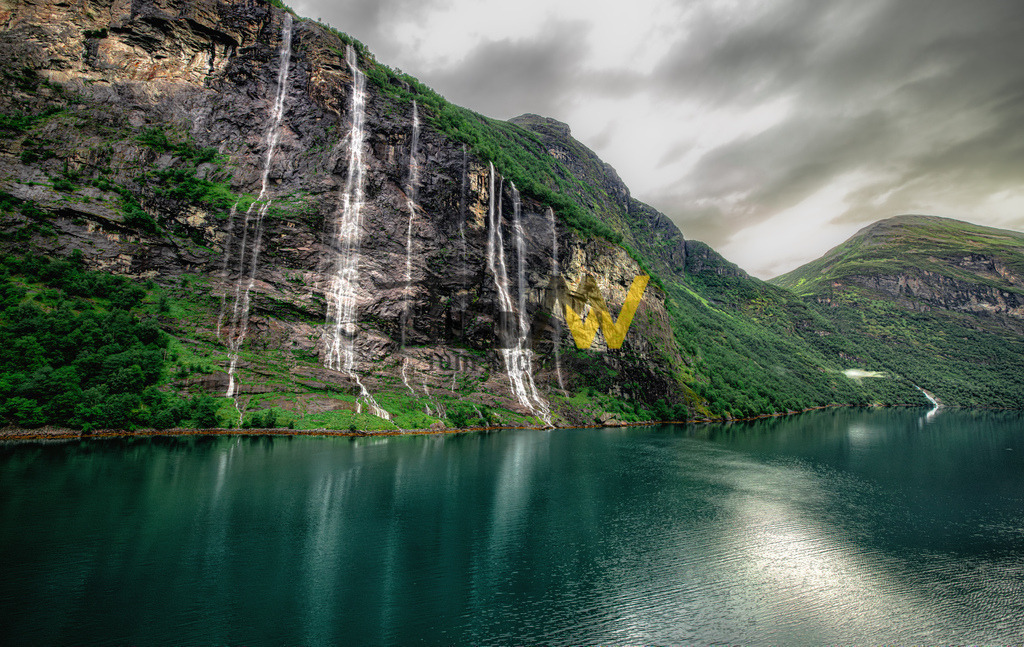 Bekannte Wasserfälle im Geirangerfjord-7 Schwestern-Norwegen | Das Bild zeigt die "Sieben Schwestern" (norwegisch: De syv søstrene), einen berühmten Wasserfall im Geirangerfjord in Norwegen. Der Wasserfall besteht aus sieben separaten Strömen, die direkt nebeneinander vom Berg in den Fjord stürzen. Die Gesamthöhe beträgt etwa 410 Meter, wobei der höchste freie Fall etwa 250 Meter misst. Die Wasserfälle sind besonders während der Schneeschmelze im Frühjahr und Sommer spektakulär. Einer Sage nach repräsentieren die sieben Ströme unverheiratete Schwestern, während ein gegenüberliegender Wasserfall, der "Freier", erfolglos um ihre Hand anhält.  - Realisiert mit Pictrs.com