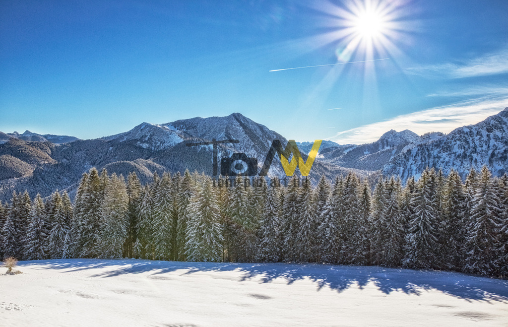 Winterlicher Bergblick Tegernsee----Traumhafte Winterszene | Winterliches Panorama von den Bayrischen Voralpen am Tegernsee.Dieses Bild zeigt eine idyllische Winterlandschaft in der Region Tegernsee, die als Motiv für verschiedene Produkte verwendet wird. Die Aufnahme zeigt eine verschneite Berglandschaft mit einem Wald im Vordergrund und strahlendem Sonnenschein.  - Realisiert mit Pictrs.com