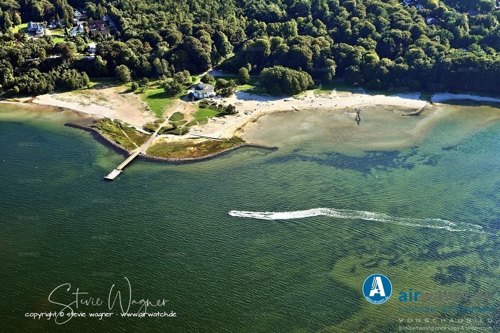 Luftbild Flensburg Solitüde - Die Geschichte des Gebietes reicht zurück bis ins 19. Jahrhundert | Die Geschichte des Gebietes reicht zurück bis ins 19. Jahrhundert, als es Eigentum der Familie Rasch war. Später wurde es Eigentum der Stadt Flensburg und 1910 wurde das Solitüder Gebiet als Teil von Twedt nach Flensburg eingemeindet. Nach dem Ersten Weltkrieg und der Volksabstimmung von 1920, bei der das nördliche Fördeufer von Flensburg an Dänemark abgetrennt wurde, wurde das Südufer der Flensburger Förde stärker belebt. In den Jahren 1922/23 wurden Sandreste von der Anlage des Freihafen-Beckens in der Bucht von Solitüde verklappt und aufgespült, was den Strand erheblich vergrößerte. 1924 wurde Solitüde schließlich zum Strandbad erklärt.