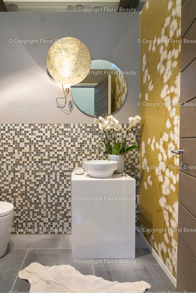 Party-WC | Besonderes Gäste-WC mit Aufsatzwaschbecken auf weißem Kubus mit Orchidee und goldenem Reflektor-Licht. Curryfarbene Tapete mit Baumwolldruck. - Realisiert mit Pictrs.com