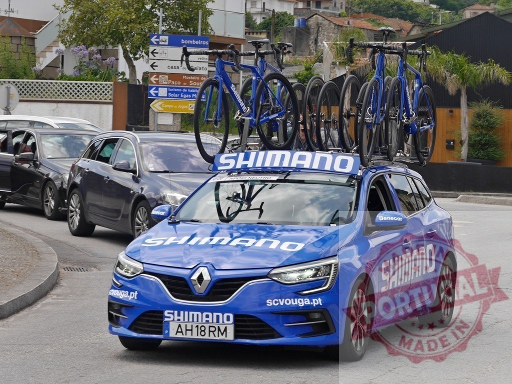 Shimano team car transporting bicycles for cycling race | Blue Renault support vehicle carrying multiple road bikes on a roof rack - Realisiert mit Pictrs.com