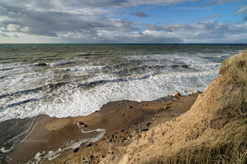Wellen am Strand bis zum Steilufer | Von der Steilküste fällt der Blick auf die hellen Muster der Schaumkronen am überfluteten Ostseestrand.