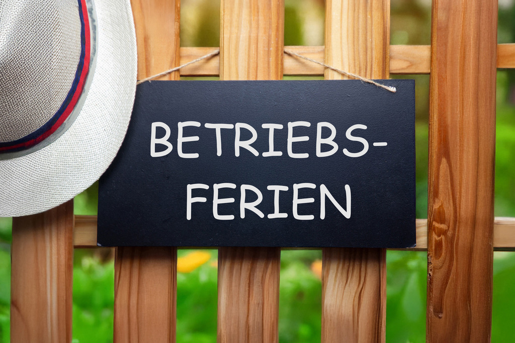Betriebsferien: Schild mit hinzugefügtem Text BETRIEBSFERIEN an einem Holzzaun | Betriebsferien: Schild mit hinzugefügtem Text BETRIEBSFERIEN an einem Holzzaun - Realisiert mit Pictrs.com
