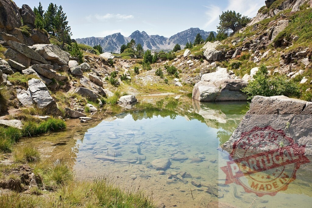 Andorra Pyrenees mountains reflecting in clear alpine lake | Clear alpine lake reflecting Pyrenees mountains and blue sky on a summer day - Realized with Pictrs.com