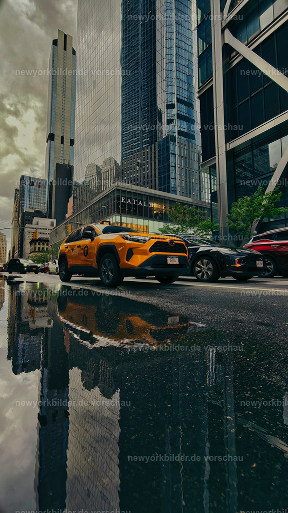 Yellow Cabs und Wolkenkratzer – Spiegelung in den Straßen von NYC | Mitten in den Straßen von Manhattan entsteht ein Moment, der die Magie des Alltags einfängt: Eine Pfütze am Bordstein verwandelt sich in einen Spiegel, in dem sich Yellow Cabs und die mächtigen Wolkenkratzer der Stadt vereinen. Diese ungewöhnliche Perspektive erzählt von Bewegung, von Licht und von der Dynamik einer Metropole, die niemals stillsteht. Die Spiegelung erzeugt ein Spiel aus Realität und Illusion – ein Blick, der den Betrachter innehalten lässt und die Schönheit im Detail offenbart. Es ist ein Bild, das die Essenz von New York transportiert: das Zusammenspiel von Architektur, Geschwindigkeit und urbanem Leben. Jeder Reflex, jede Linie in der Wasserfläche wirkt wie ein Kunstwerk, geschaffen von Zufall und Stadtlicht. Dieses Motiv ist mehr als eine Szene – es ist ein Statement für die Energie und den Charakter des Big Apple, eingefangen in einem Augenblick, der so flüchtig wie einzigartig ist.