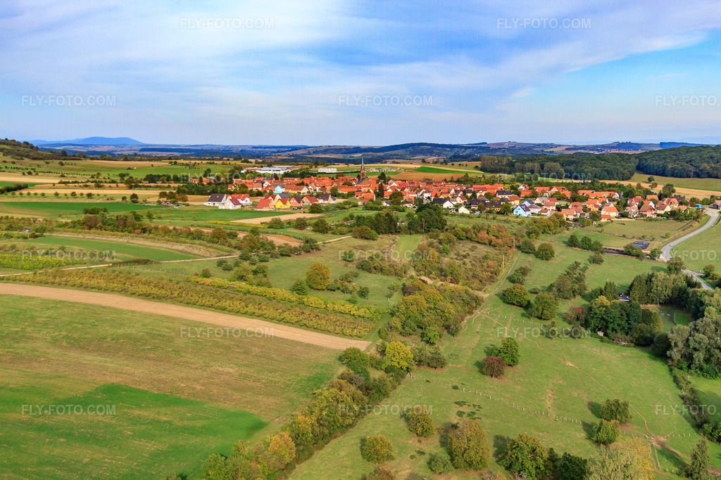 Aerial view: Village view from the west beyond the Étang de pêche APP Imbsheim in Bouxwiller in the state Bas-Rhin, France. – Photo: IMG_53608.jpg taken on 09/30/2012 by Werner Riehm/FLY-FOTO.com – Resolution of the original: 4752 x 3168 px