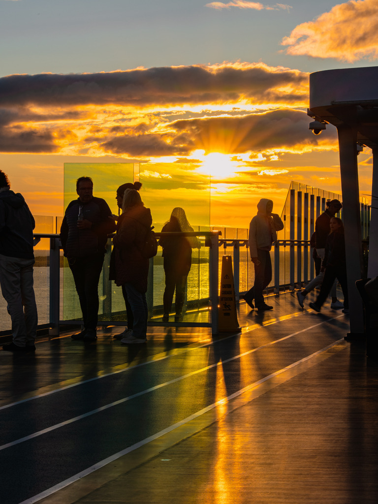 Sonnenuntergang auf der Mein Schiff 2 | Friedliche Momente im Gegenlicht: Menschen als Schattenrisse blicken gemeinsam in einen dramatischen Sonnenuntergang am Horizont der Mein Schiff 2. - Realisiert mit Pictrs.com