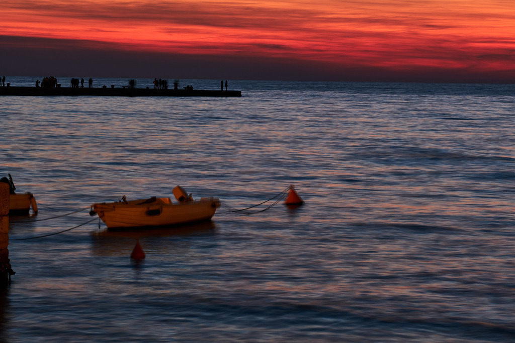 Blick auf das Meer im Abendrot | Triest, Austria - March 10, 2022: Canal Grande di Trieste; Blick auf das Meer im Abendrot mit Boot. - Realisiert mit Pictrs.com