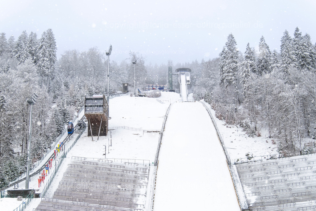 Absprungbereich der Mühlenkopfschanze in Willingen im Januar | Die Mühlenkopfschanze in Willingen, Deutschland. Die Tribünen sind menschenleer, es schneit und es sind optimale Bedingungen für das Skispringen.