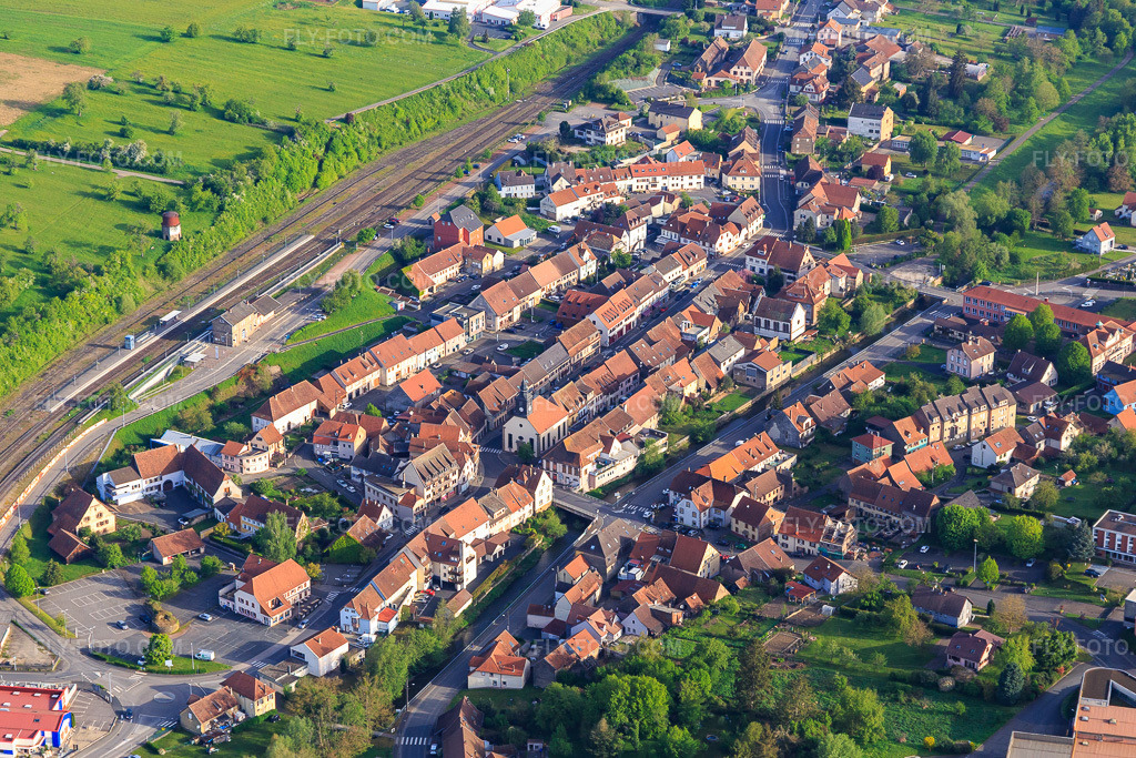 Aerial view: Village on the railway line from the south in Diemeringen in the state Bas-Rhin, France. – Photo: IMG_140641.jpg taken on 05/01/2024 by Werner Riehm/FLY-FOTO.com – Resolution of the original: 5205 x 3470 px