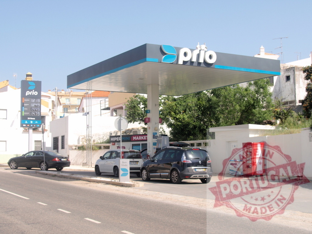 Prio gas station in Portugal with cars fueling | Prio gas station on a sunny day with vehicles at the pumps and a price sign - Realisiert mit Pictrs.com