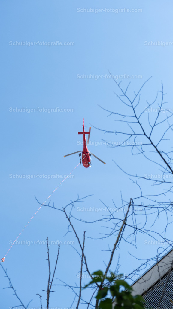 Helikopter im Einsatz | roter Helikopter der Gegenstände Transportiert - Realisiert mit Pictrs.com