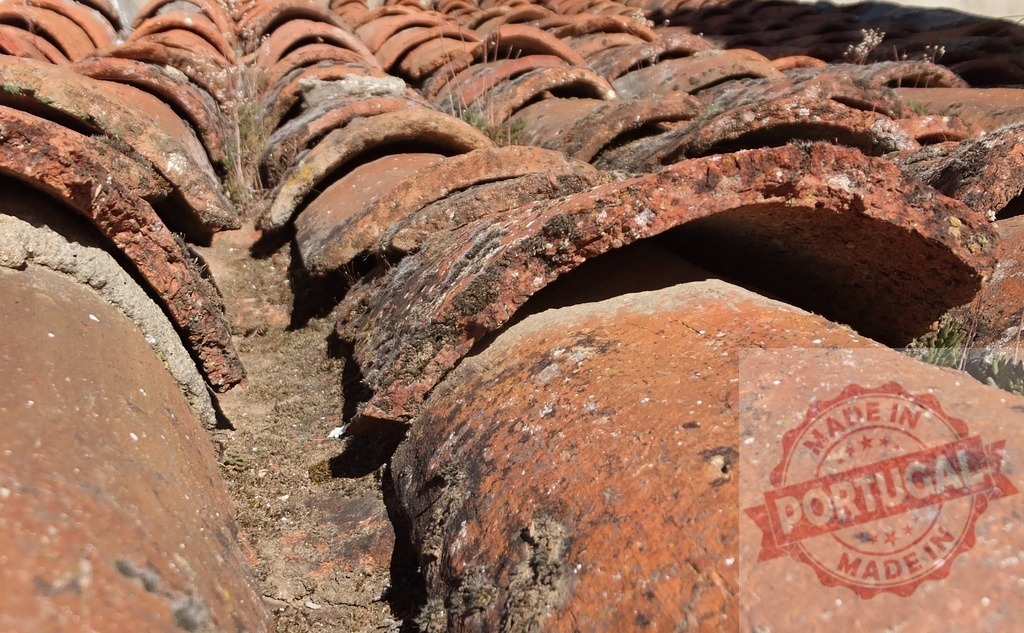 Old terracotta roof tiles covering a building | Close up view of aged and weathered terracotta roof tiles, showing signs of wear and tear - Realisiert mit Pictrs.com