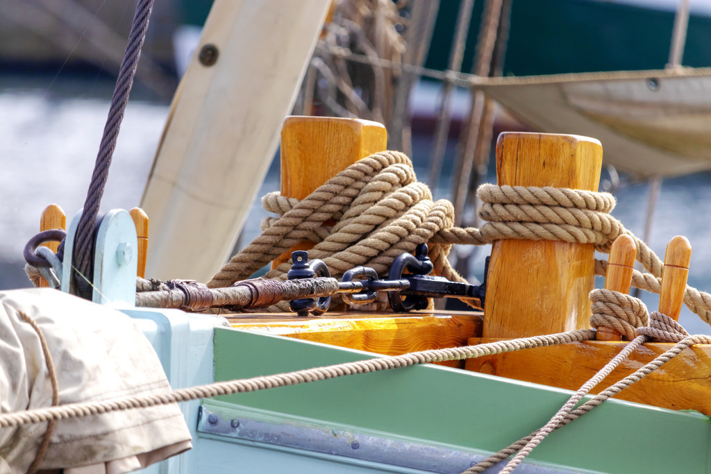 Wandbild: Seile am Boot im Hafen von Eckernförde | Dieses Wandbild im Querformat zeigt ein Boot und Seile in Nahaufnahme in Eckernförde. Ein schönes Maritimes Motiv für Ihre Wände. - Realisiert mit Pictrs.com