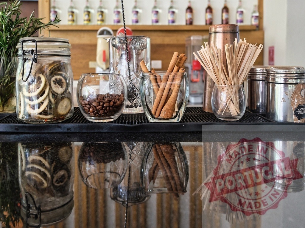Bar counter displaying cocktail ingredients and reflections | Bar counter displaying dried fruit, coffee beans, cinnamon sticks and stirrers with reflections - Realisiert mit Pictrs.com