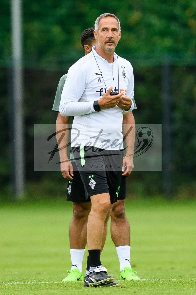 TRABMG20210719_118 | Fussball, Herren: Trainer Adi Huetter (Borussia Moenchengladbach) schaut beim Training von Borussia Moenchengladbach waehrend des Trainingslagers auf dem Trainingsplatz am Hotel Klosterpforte am 19.07.2021 in Harsewinkel, Deutschland. - Realisiert mit Pictrs.com