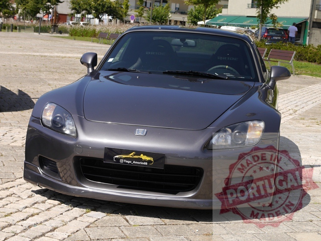 Honda S2000 grey sports car parked outdoor | Honda S2000 sports car parked on a paved square under daylight - Realized with Pictrs.com