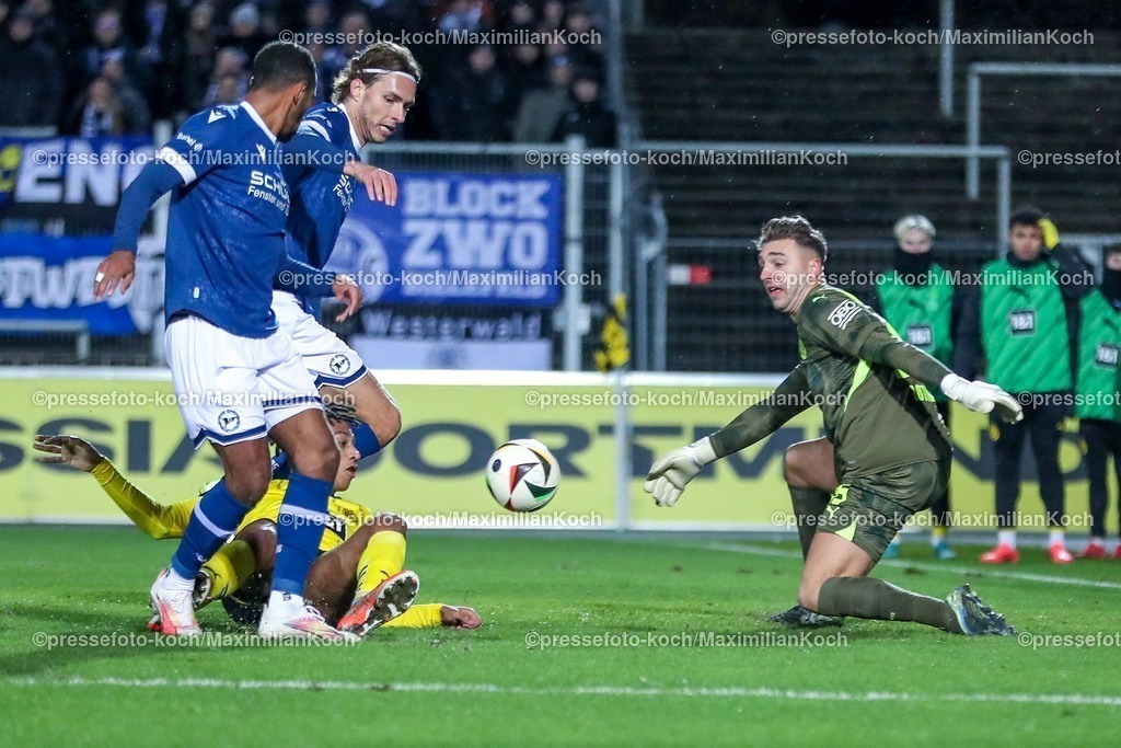BVBII26012501013 | 26.01.2025, Fußball, 3.Liga, Borussia Dortmund II - Arminia Bielefeld, Stadion Rote Erde, Saison 2024 2025: Roberts Uldrikis (Arminia #28) behauptet sich im Zweikampf gegen Filippo Mané (BVBII #22) und Torwart Marcel Lotka (BVBII #35) und trifft zum 1:0DFB regulations prohibit any use of photographs as image sequences and or quasi-video.