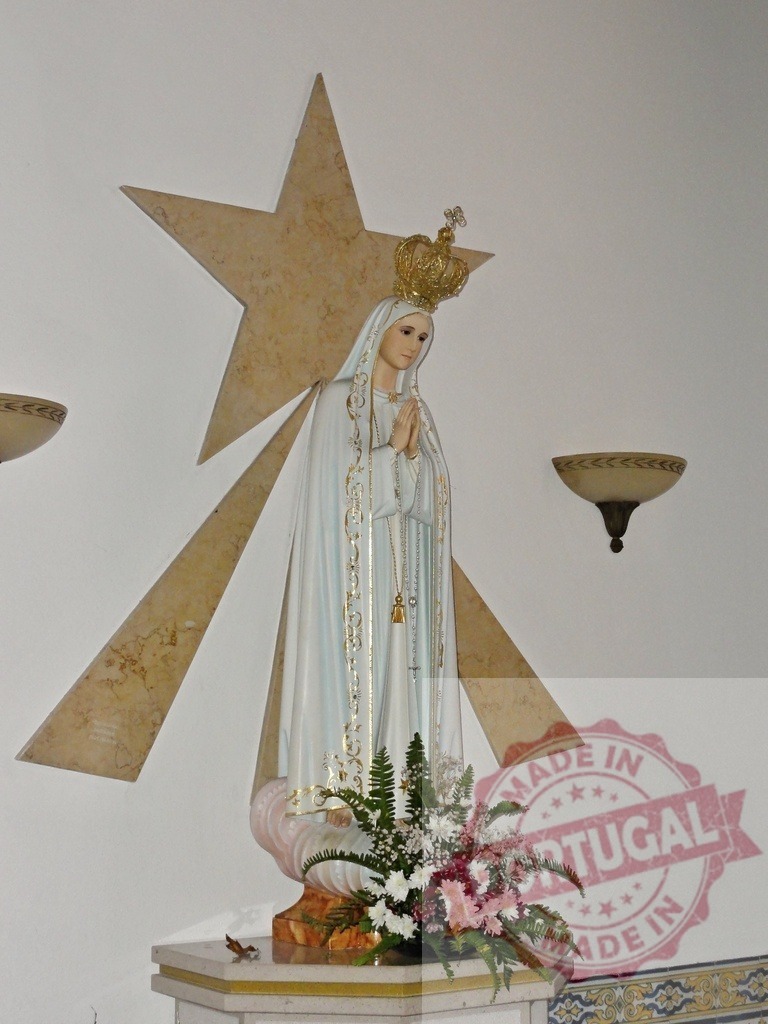 Statue of our lady of fatima praying with crown and star behind | Statue of our lady of fatima with crown, star and flowers in a church - Realisiert mit Pictrs.com
