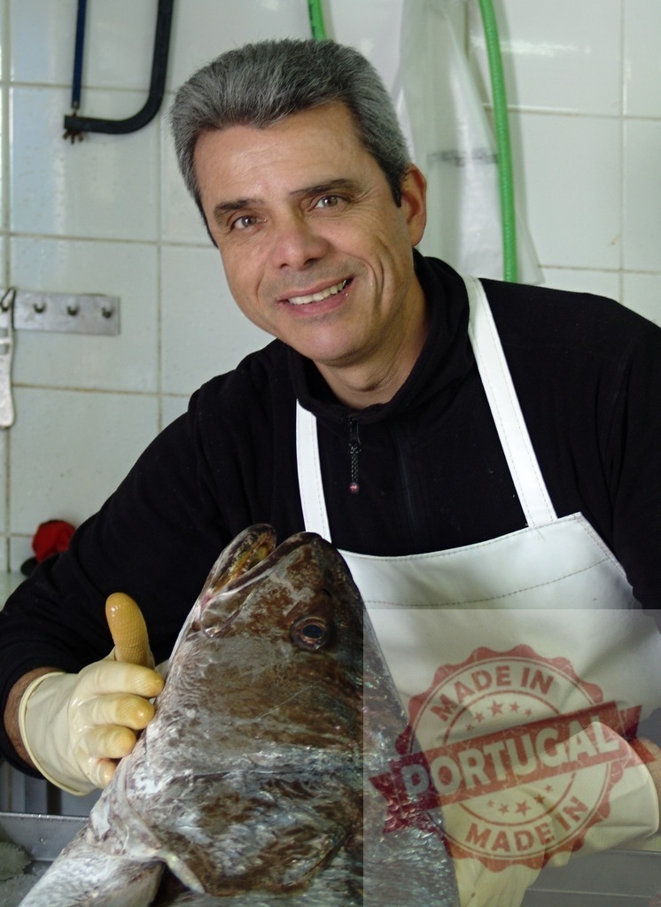Fishmonger seller presenting fresh fish from market | Man in apron and gloves smiling, proudly holding a large fresh fish - Realized with Pictrs.com