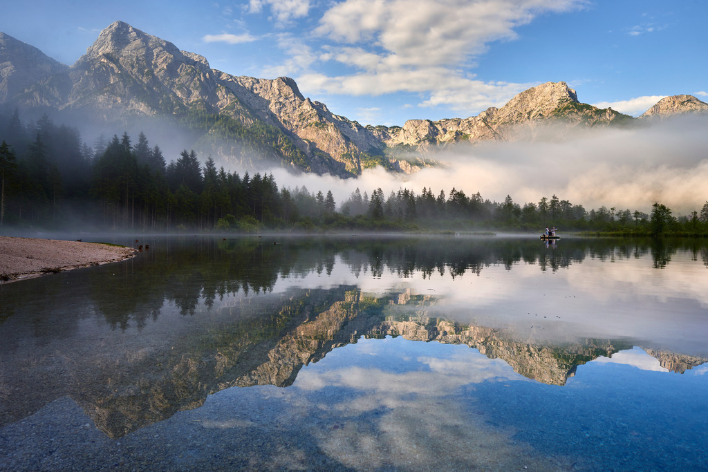 Drei Angler im Fischerboot | Gruenau im Almtal, Austria - July 23, 2016: Drei Angler im Fischerboot auf dem Almsee. Im Hintergrund das Tote Gebirge im Morgenlicht und Nebelstreifen. - Realisiert mit Pictrs.com