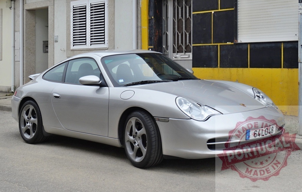 Porsche 911 Carrera 996 silver sports car parked on street | Silver Porsche 911 Carrera 996 coupe parked on a city street beside a building - Realisiert mit Pictrs.com
