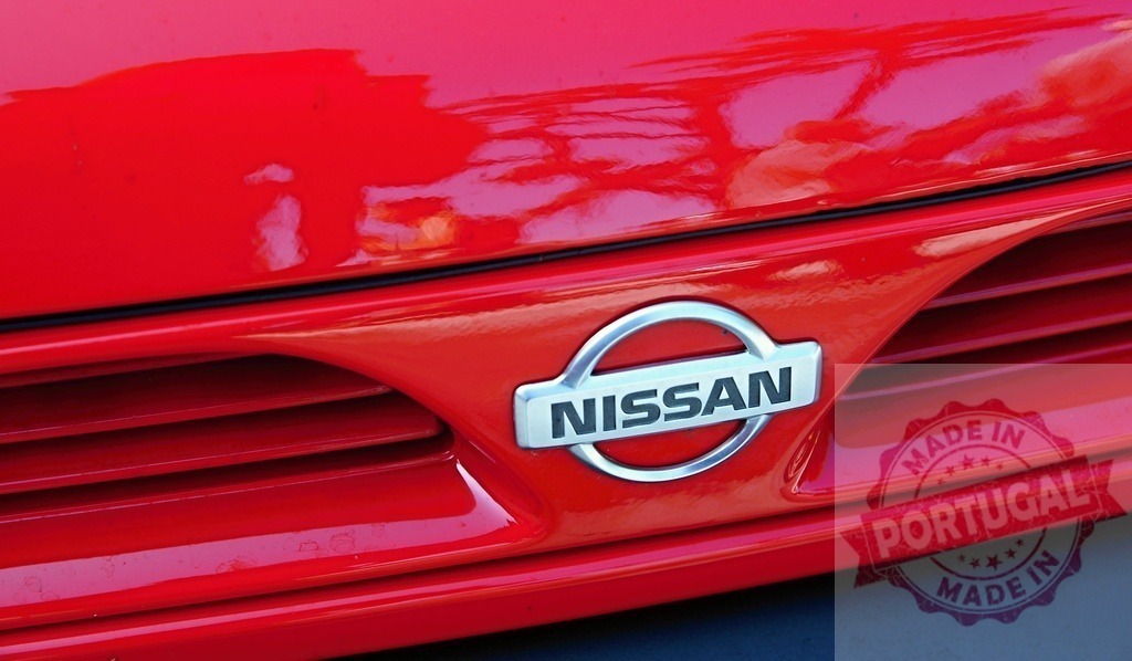 Shiny red Nissan logo reflecting the sky | Close-up of a red Nissan car with the logo reflecting the sky - Realisiert mit Pictrs.com