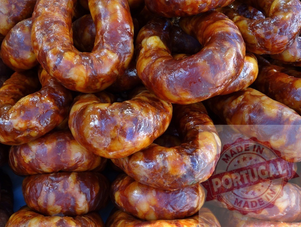 Stacked smoked chorizo sausages ready for consumption | Rows of traditional Portuguese or Spanish chorizo sausages forming a delicious background - Realized with Pictrs.com