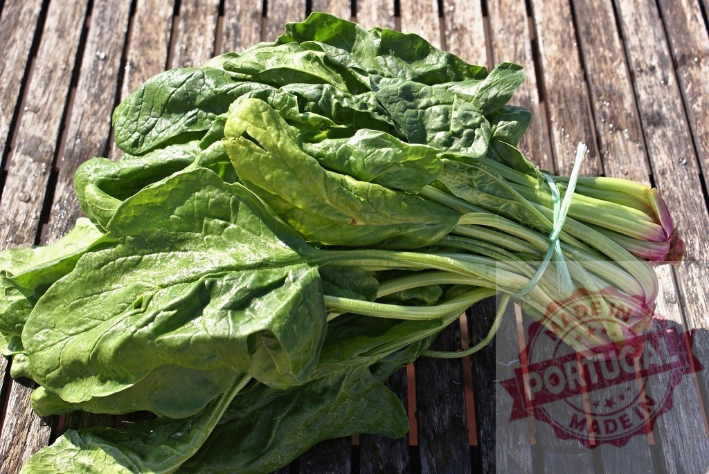 Fresh green spinach bunch on rustic wood table | Freshly harvested green spinach leaves bundled together on a natural wooden surface - Realized with Pictrs.com