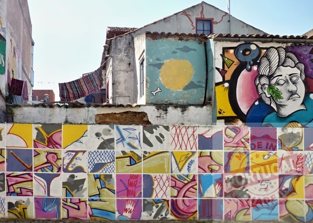 Vibrant street art mural on urban wall | Colorful tiled wall featuring graffiti and a laundry line in an urban setting - Realized with Pictrs.com