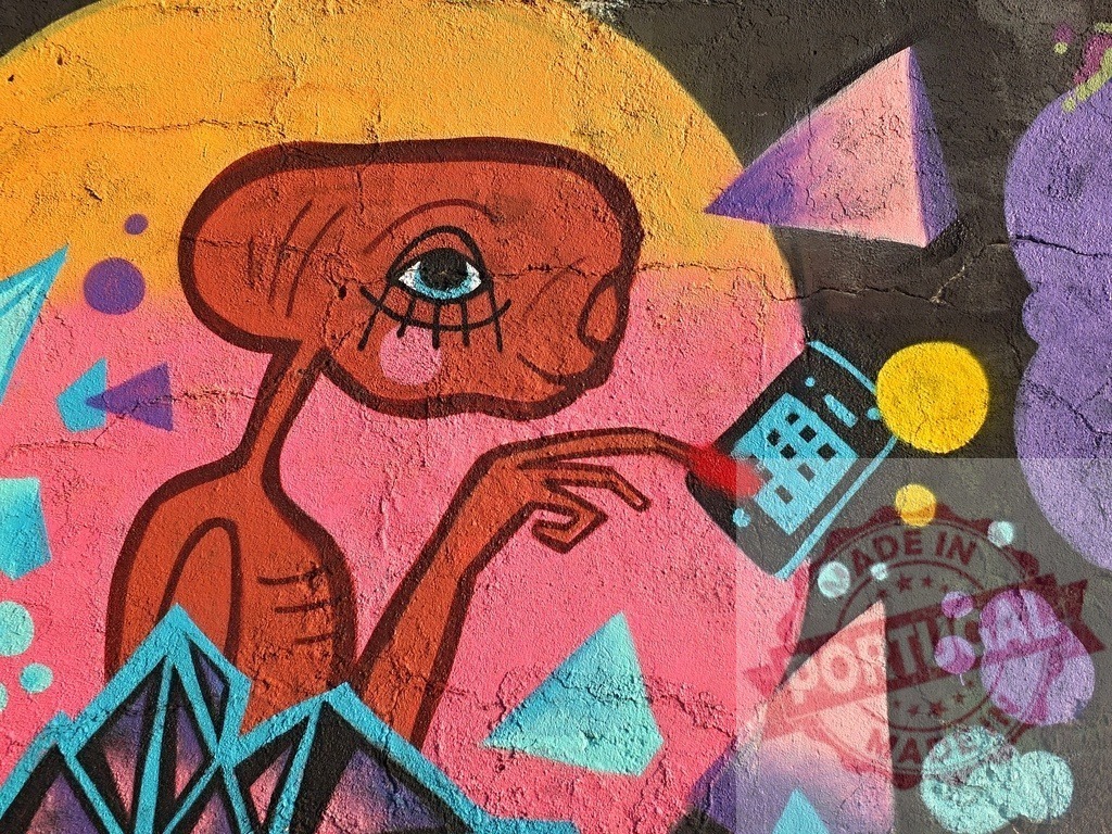 E.T. Alien street art mural with phone | Colorful graffiti painting E.T. Touching a cell phone on a textured wall - Realized with Pictrs.com