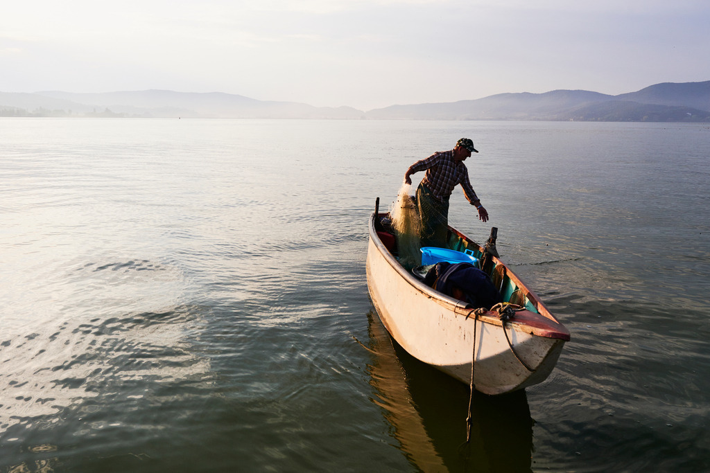 Fischer auf dem Boot | San Feliciano, Italien - August 31, 2016: Lago Trasimeno; Fischer auf dem Boot im Morgenlicht. - Realisiert mit Pictrs.com
