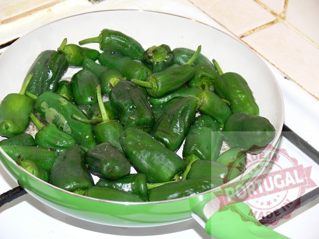 Padrón peppers frying in a green pan | Padrón peppers cooking in a frying pan, ready to be served - Realized with Pictrs.com