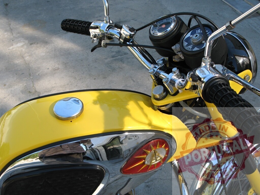 Yellow vintage motorcycle reflecting sunlight on gas tank | Close-up of a yellow vintage motorcycle with chrome details, reflecting sunlight on the gas tank - Realized with Pictrs.com