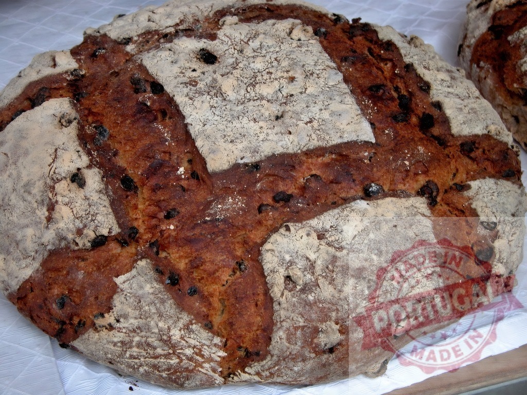 Rustic artisan raisin bread loaf baking fresh | Rustic artisan raisin bread loaf with flour dusting and scoring, ready for market - Realisiert mit Pictrs.com