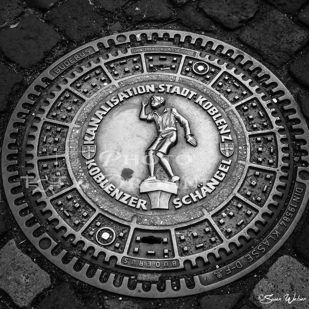 Koblenz- | In der Kobenzer Altstadt gibt es einzigartige Kanaldeckel zu bestaunen und fotografieren. Koblenz ist die Stadt am Zusammenfluss von Rhein und Mosel. Am Deutschen Eck treffen die beiden großen Flüße aufeinander. Koblenz hat eine sehenswerte Altstadt. Es gibt viel Historisches und Modernes zu entdecken. - Realisiert mit Pictrs.com