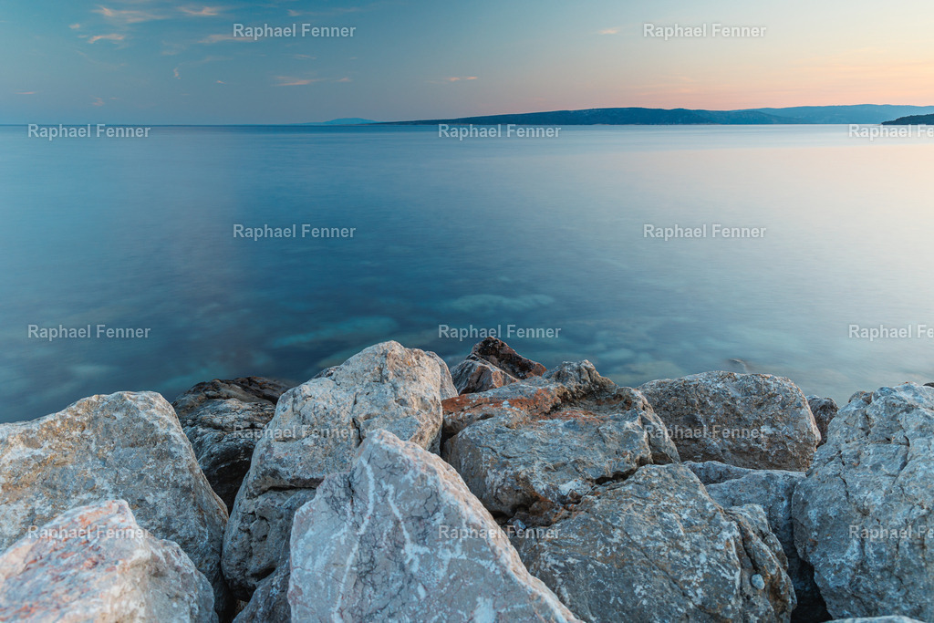 Felsenküste auf Krk – Blau trifft Stein | Aufgenommen auf der Insel Krk in Kroatien. Die massiven Felsen im Vordergrund treffen auf das weite, tiefblaue Wasser der Adria – ein Bild voller Kontraste und zugleich Ruhe. Die klaren Farben und die minimalistische Komposition machen dieses Motiv zu einem starken Fine Art Print für moderne Räume mit maritimem Flair.