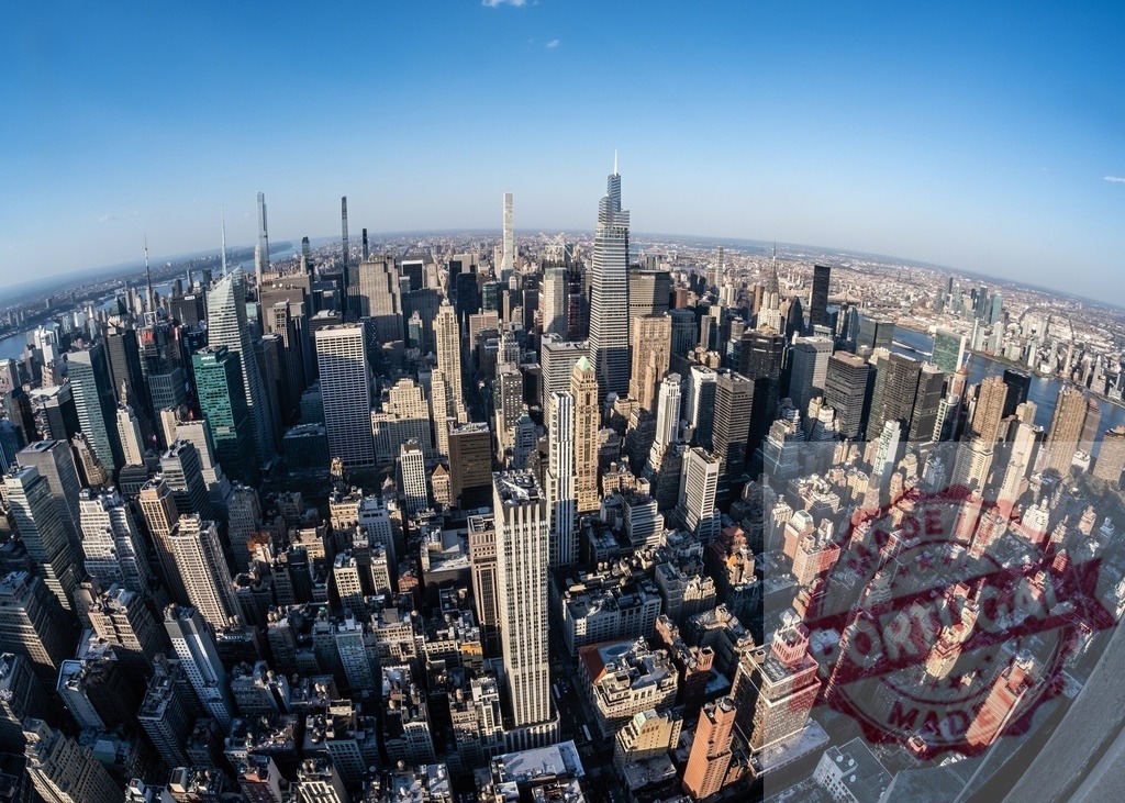 Fisheye lens capturing Manhattan skyline with skyscrapers rising above New York City under blue sky | Breathtaking aerial view of Manhattan's urban landscape, showcasing towering skyscrapers and iconic landmarks under a vibrant blue sky - Realized with Pictrs.com