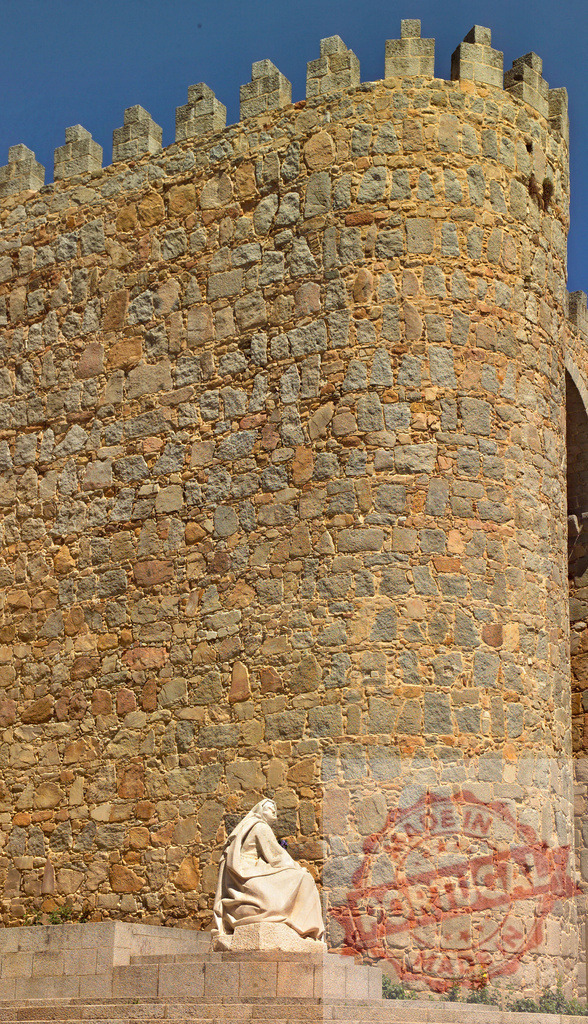 Saint Teresa of Avila statue and medieval city walls in Spain. Spain - Avila | Stone statue of Saint Teresa of Avila sitting by the ancient Walls of Avila - Realisiert mit Pictrs.com