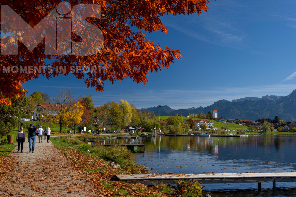 2.Liga-1860-HEIM.jpg | 17.10.2022, Herbst am Hopfensee im Allgäu (Bayern) bei Füssen. Bei sommerlichen Temperaturen geniessen viele Ausflügler die herbstliche Landschaft am See mit bunt gefärbtem Herbstlaub. Hier die Promenade in Hopfen am See. - Realisiert mit Pictrs.com