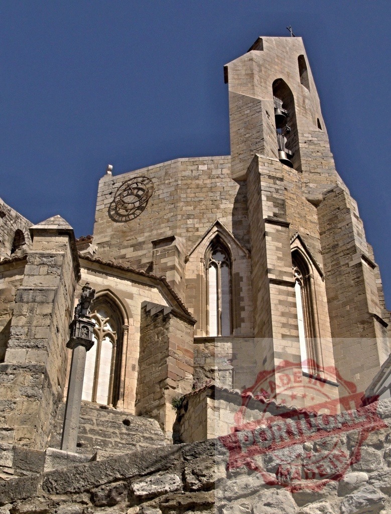 Ancient stone gothic church bell tower against blue sky | Ancient stone church showcasing Gothic architecture and a bell tower under a clear blue sky - Realized with Pictrs.com