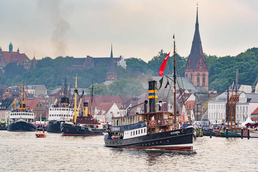 Alexandra, Salondampfer | Im Jahr 1908 lief der Salondampfer Alexandra vom Stapel. Das 37 Meter lange Schiff ist der letzte erhaltene Fördedampfer und hat seinen Liegeplatz im Hafen von Flensburg. Das Bild zeigt die Alexandra während eines Dampf Rundum´s, bei dem etliche Dampfschiffe in Flensburg ein Dampferrennen um das blaue Brauerband fahren. - Realisiert mit Pictrs.com