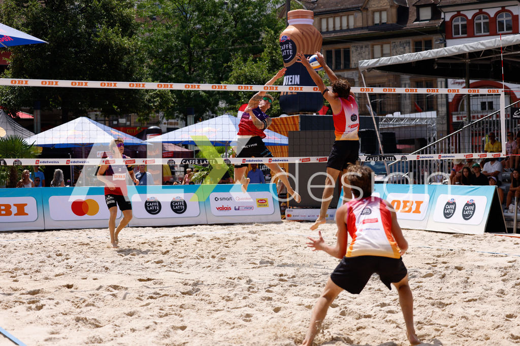 Obi BeachTour 2026 - Basel | BASEL, SWITZERLAND - JULY 17: NOAH YANNIK ALOIS FURRER (SUI) attack / spike against DANIEL ALLEMANN (SUI) blocking during the Obi BeachTour 2026 match between ALLEMANN / LEFFLER (SUI) and FURRER / WYMANN (SUI) at Barfüsserplatz on July 17, 2026 in Basel, Switzerland. - Realisiert mit Pictrs.com