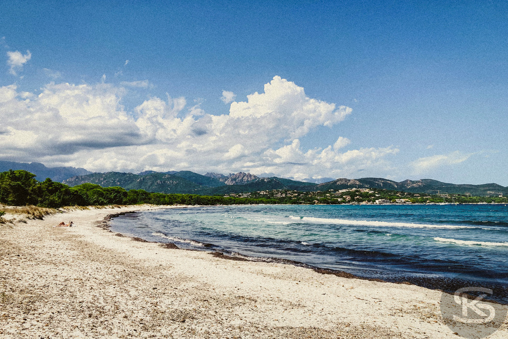 Idyllischer Sandstrand auf Korsika mit kristallklarem Wasser und mediterraner Landschaft | Ein ruhiger, sonnenverwöhnter Sandstrand auf Korsika mit türkisblauem Meer, sanften Wellen und grüner Hügellandschaft im Hintergrund – perfekte Kulisse für einen entspannten Tag in der Natur. - Realisiert mit Pictrs.com